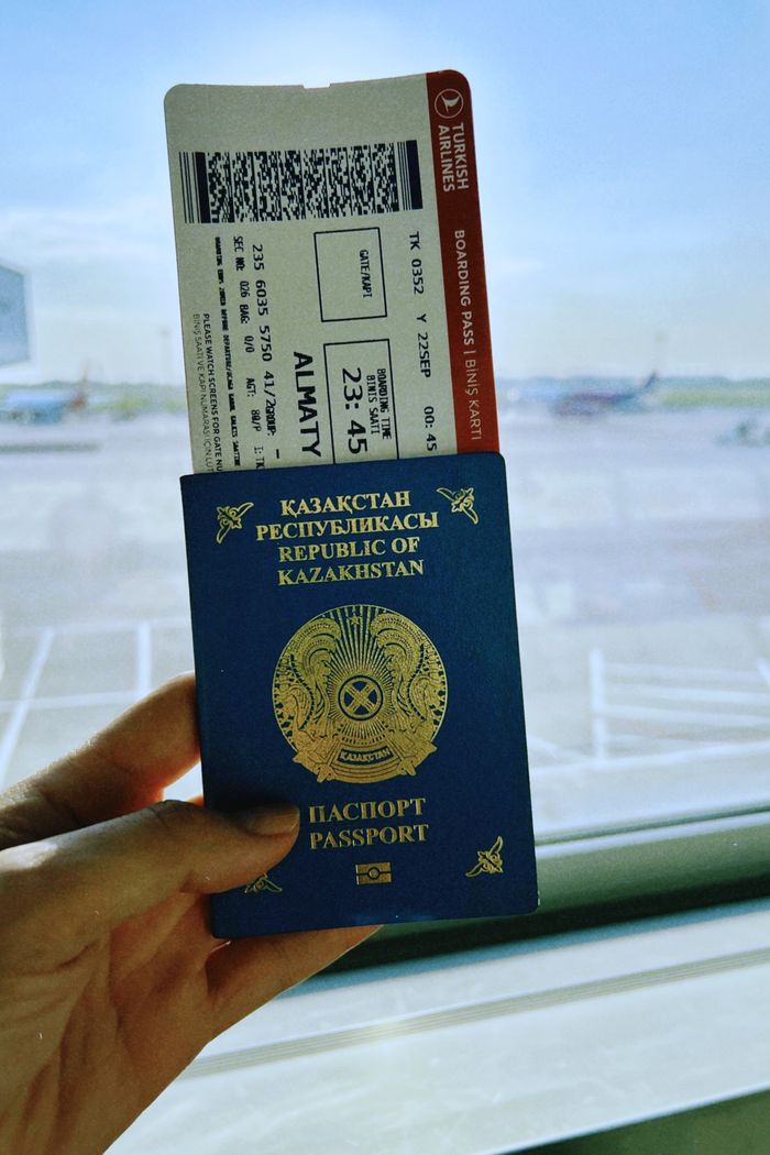social-feed-img-01 Kazakhstan passport with boarding pass in Warsaw airport, ready for travel.