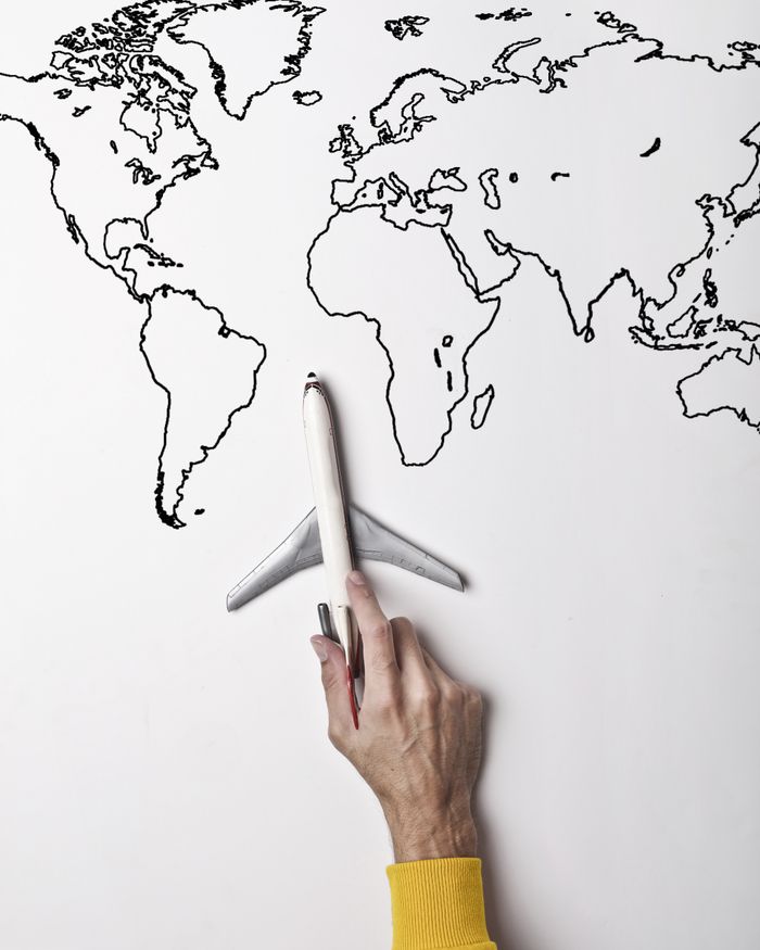 social-feed-img-05 Crop person in vibrant yellow clothes holding little gray plane against contour map on white wall as concept of tourism and adventure